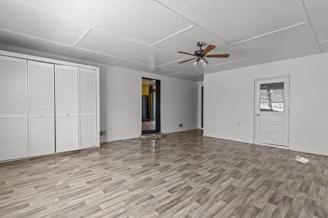 a view of a livingroom with a ceiling fan window and a ceiling fan