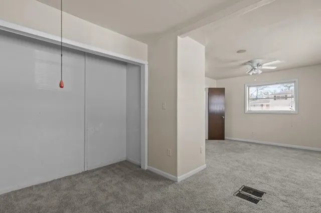an empty room with windows and closet