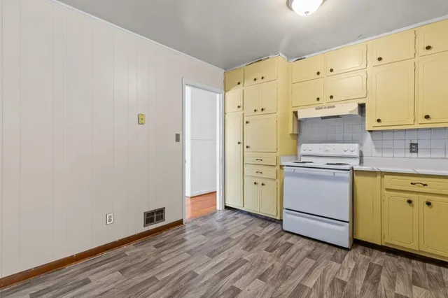 a kitchen with granite countertop white cabinets and stainless steel appliances