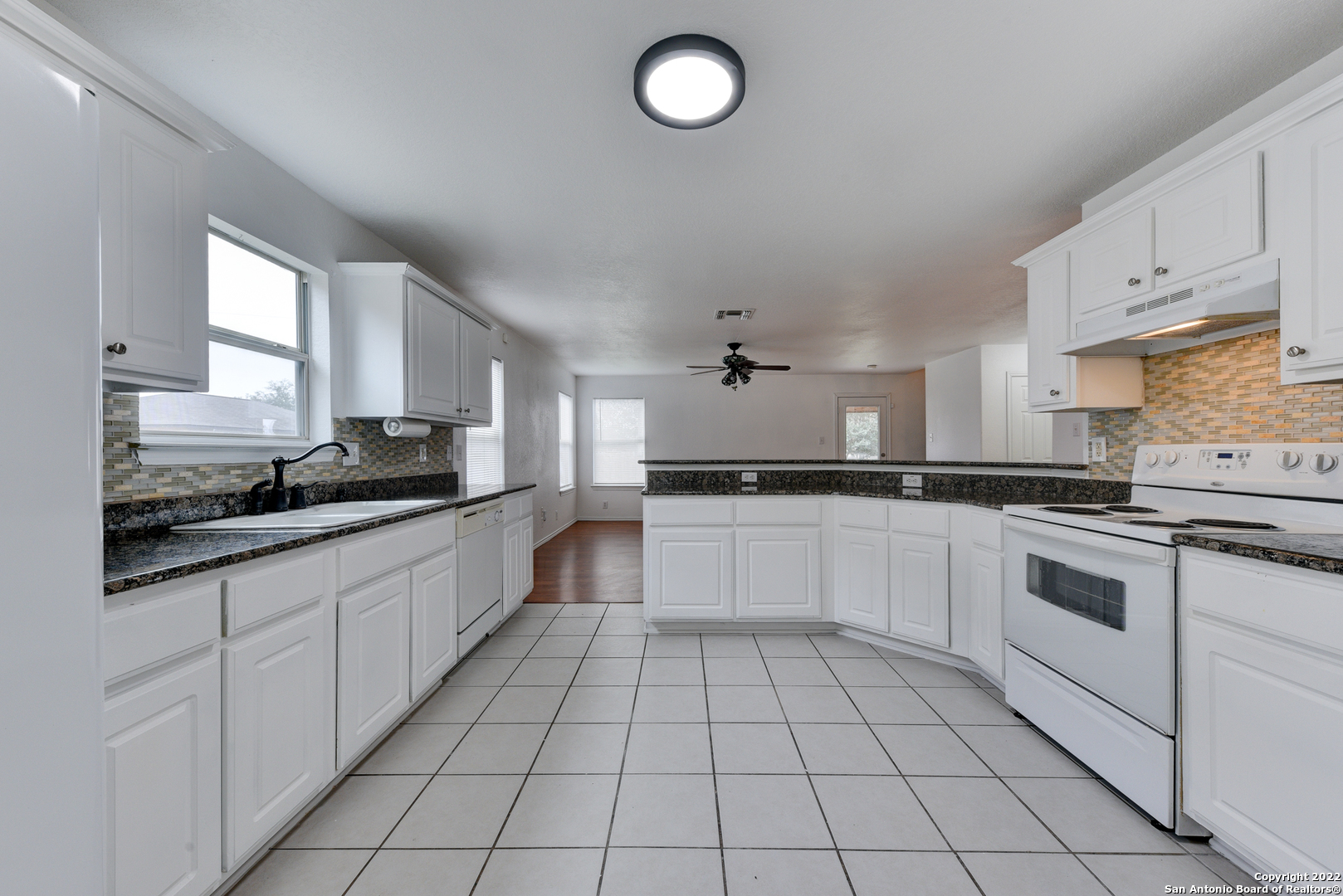 a large kitchen with white cabinets and appliances
