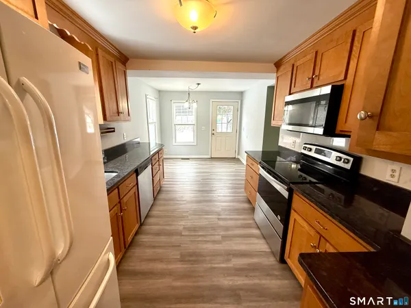 a view of a kitchen with wooden floor and staircase
