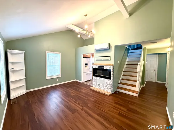 a view of a livingroom with wooden floor and stairs