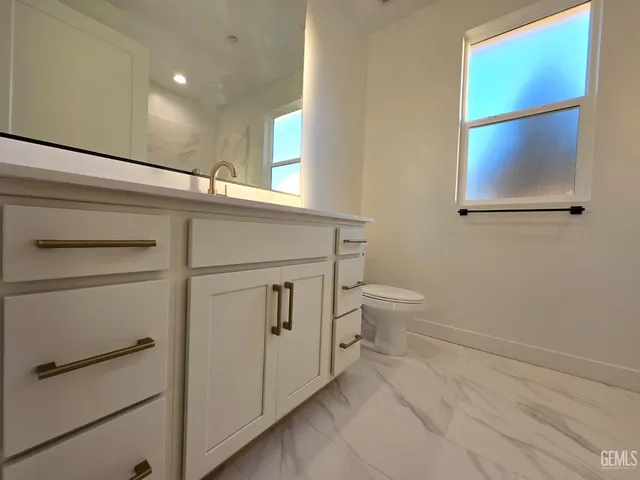a bathroom with a toilet sink and a mirror
