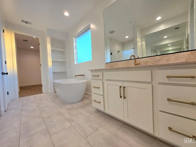 a spacious bathroom with a double vanity sink and a mirror