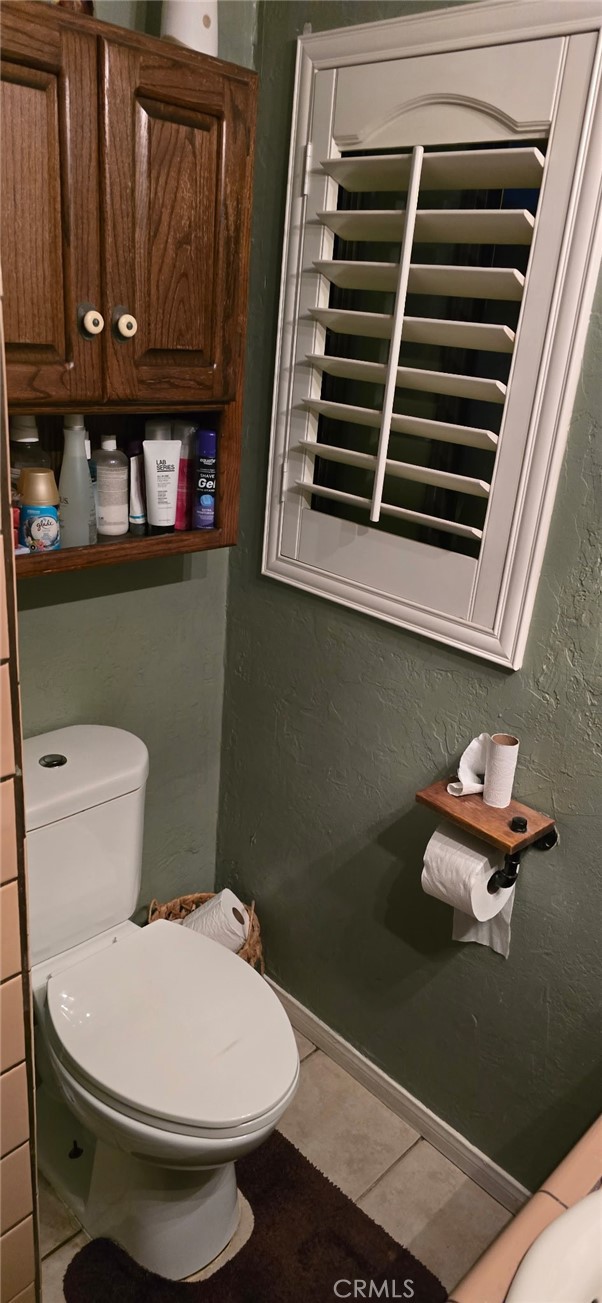 11826 Studebaker Road Norwalk, CA 90650 - Photo 9 of 15 a bathroom with a toilet a sink and a window