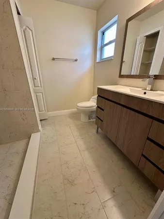 a bathroom with a sink a toilet and mirror