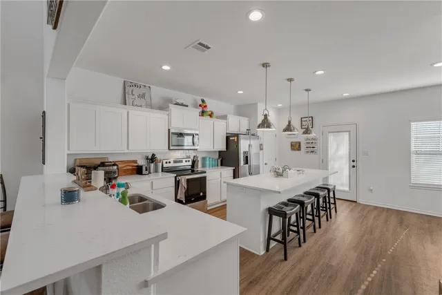 a kitchen with white cabinets and stainless steel appliances