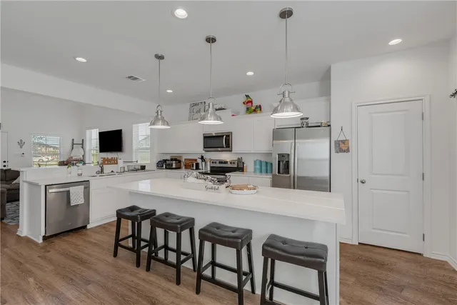 a large kitchen with kitchen island a dining table and chairs