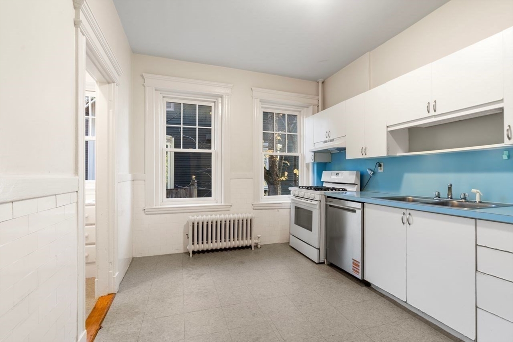 441 Washington Street, Unit 2 Brookline, MA 02446 - Photo 11 of 28 a kitchen with white cabinets and white appliances