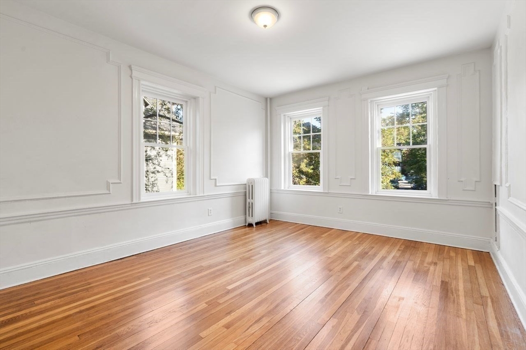 441 Washington Street, Unit 2 Brookline, MA 02446 - Photo 16 of 28 an empty room with wooden floor and windows