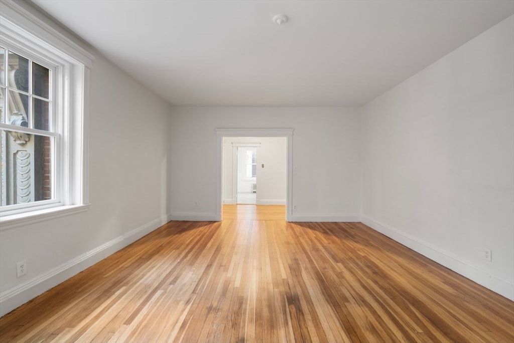 441 Washington Street, Unit 2 Brookline, MA 02446 - Photo 8 of 28 a view of an empty room with wooden floor and a window