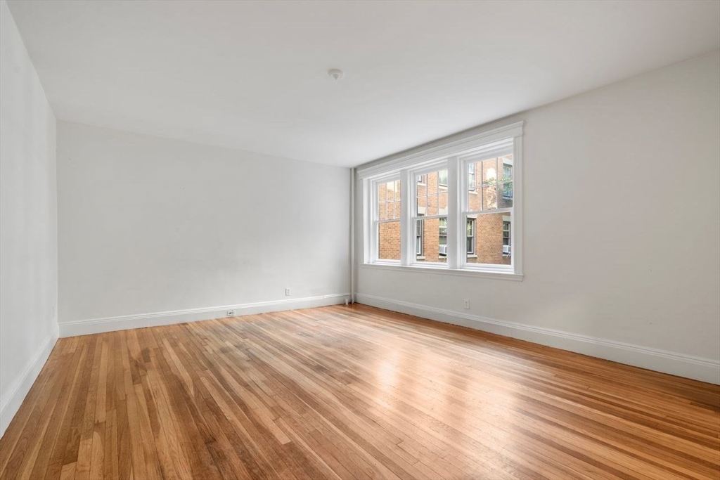 441 Washington Street, Unit 2 Brookline, MA 02446 - Photo 9 of 28 a view of an empty room with wooden floor and a window