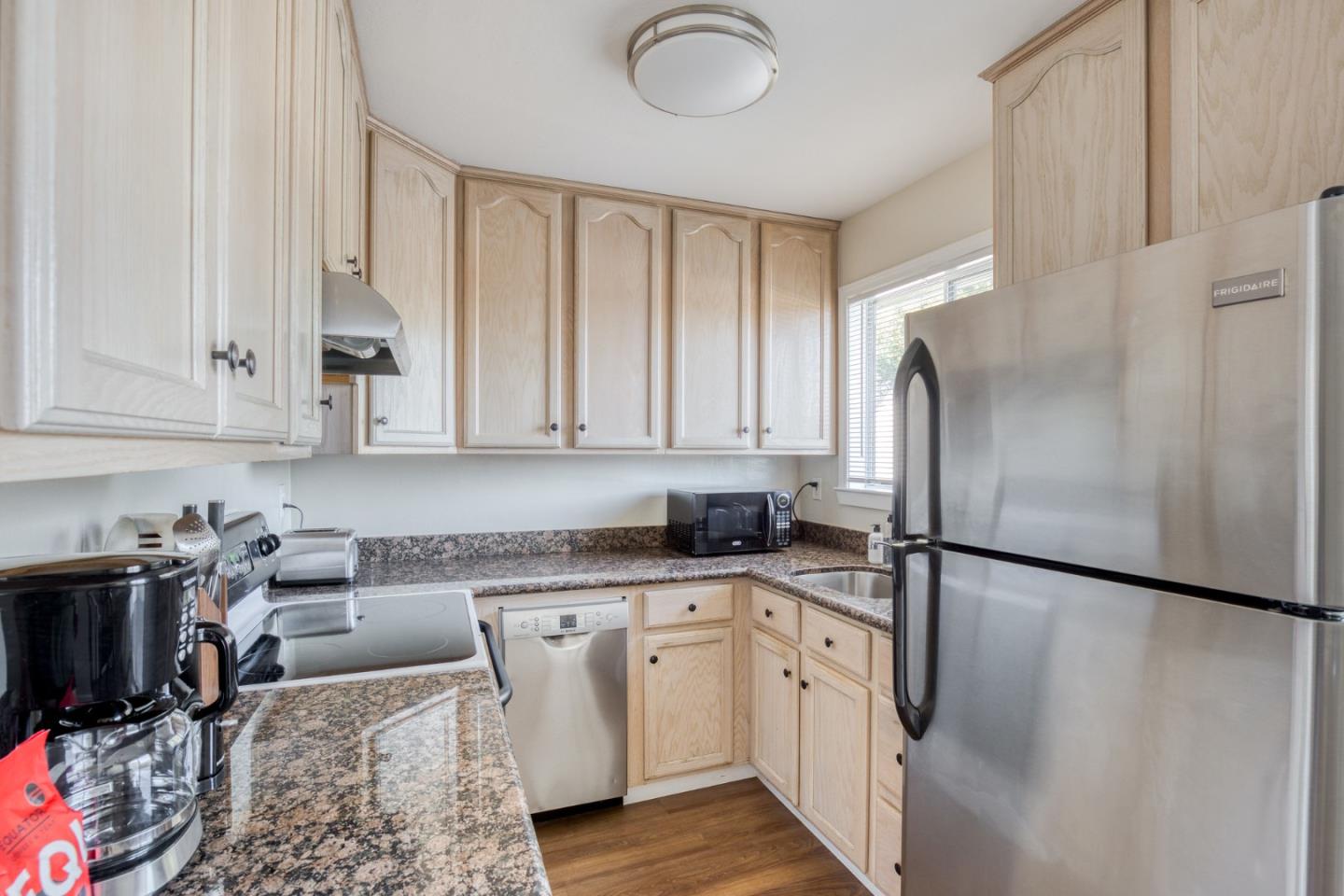 184 Centre Street Mountain View, CA 94041 - Photo 17 of 22 a kitchen with stainless steel appliances granite countertop a refrigerator a sink dishwasher and white cabinets with wooden floor