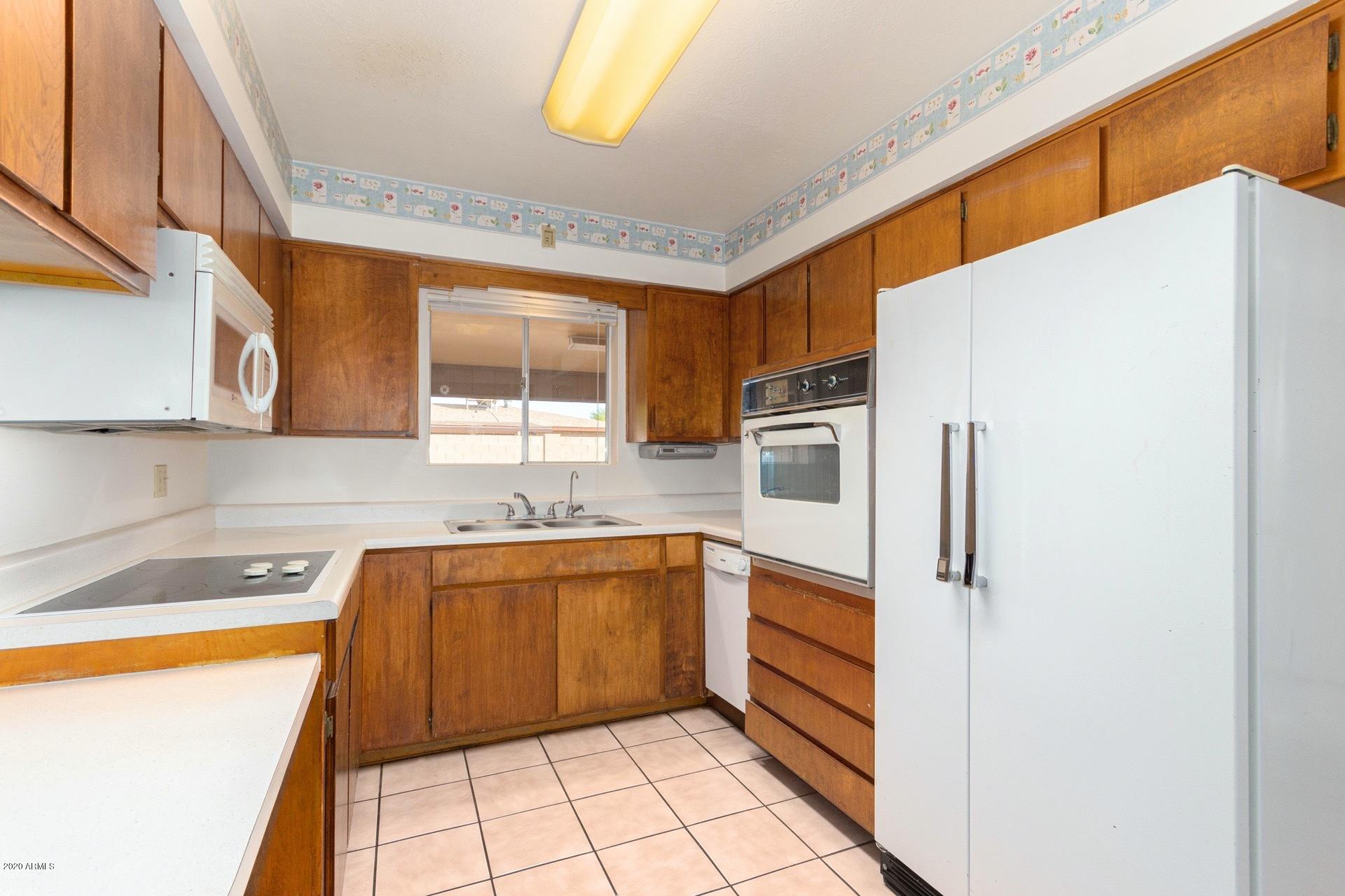 5704 East Decatur Street Mesa, AZ 85205 - Photo 12 of 40 a kitchen with stainless steel appliances a sink and a refrigerator