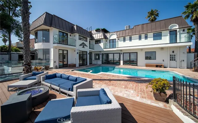 a kitchen with stainless steel appliances kitchen island granite countertop a refrigerator a stove a sink and white cabinets with wooden floor