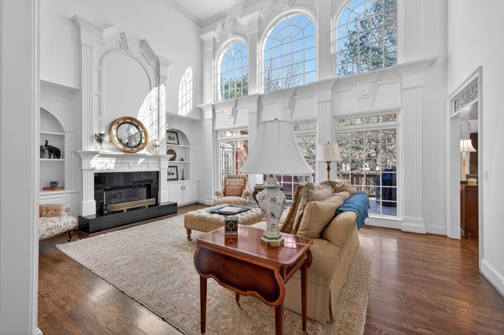 2761 Calloway Court Duluth, GA 30097 - Photo 14 of 124 a living room with furniture a fireplace a clock and a large window