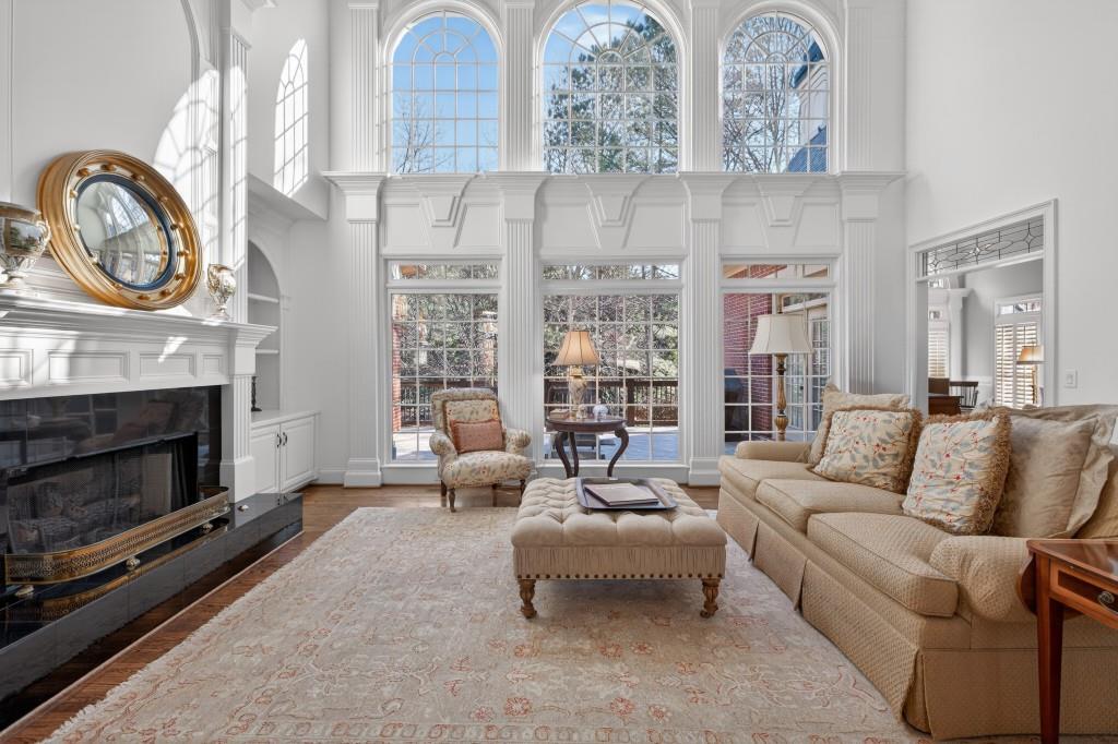 2761 Calloway Court Duluth, GA 30097 - Photo 18 of 124 a living room with furniture a fireplace a clock and a large window