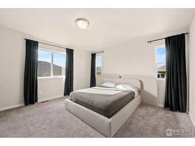 a bedroom with a bed and a large window