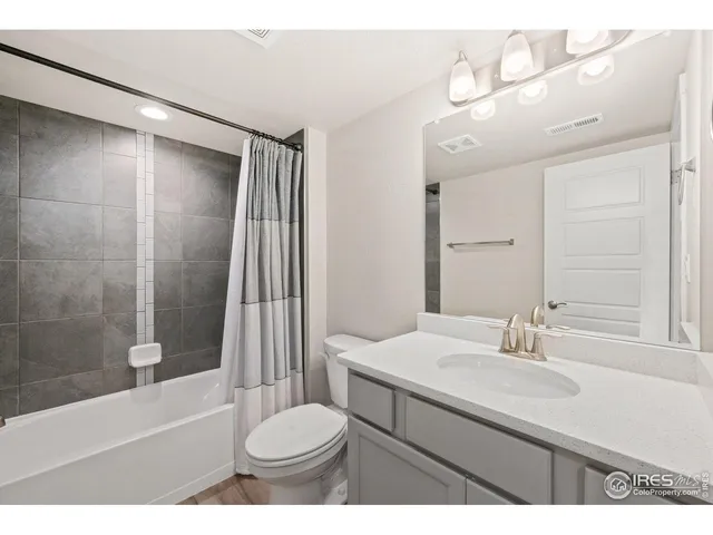 a bathroom with a sink a toilet a mirror and shower