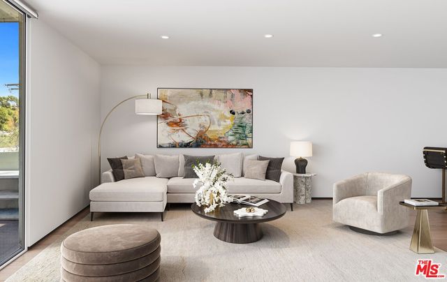 a living room with furniture and a painting on the wall