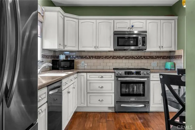 a kitchen with stainless steel appliances granite countertop a stove microwave and refrigerator