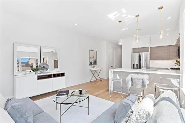 a living room with furniture and kitchen view