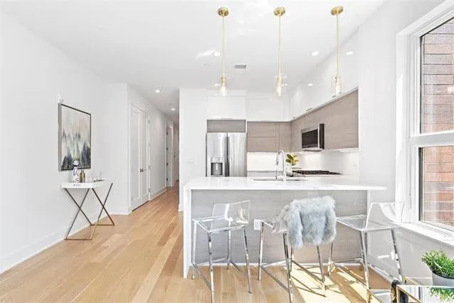 a large kitchen with stainless steel appliances kitchen island granite countertop a large cabinets a sink and a counter top space