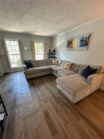 a living room with furniture and wooden floor