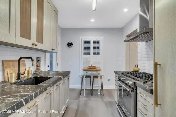 a kitchen with stainless steel appliances granite countertop a sink stove and refrigerator