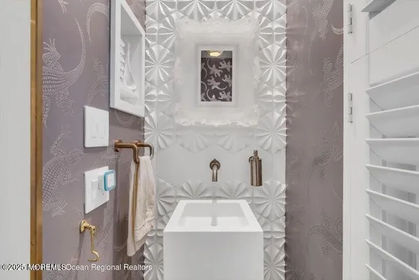 a bathroom with a sink and mirror with bathtub