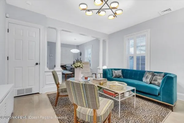 a living room with furniture a chandelier and a dining table