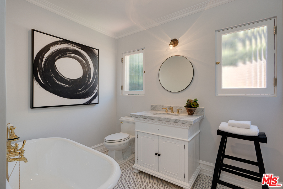 2529 North Commonwealth Avenue Los Angeles, CA 90027 - Photo 29 of 45 a bathroom with a toilet a sink a mirror and a window