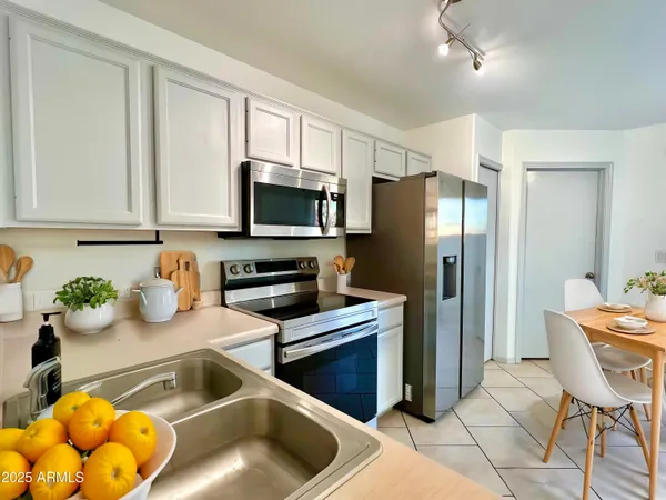a kitchen with stainless steel appliances granite countertop a refrigerator sink and stove