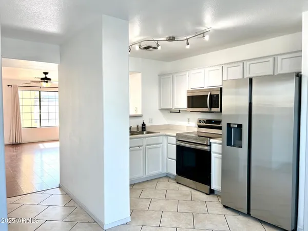 a kitchen with stainless steel appliances granite countertop a refrigerator and a sink
