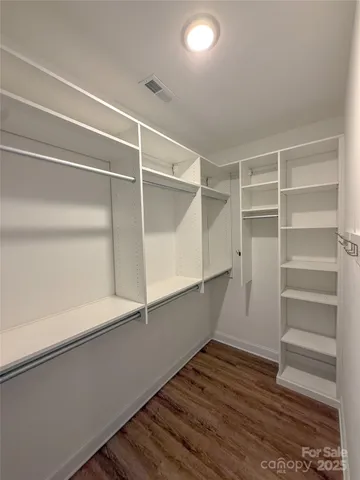 a view of walk in closet with empty racks