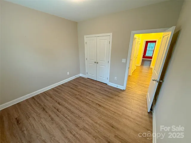 a view of empty room with wooden floor and front door