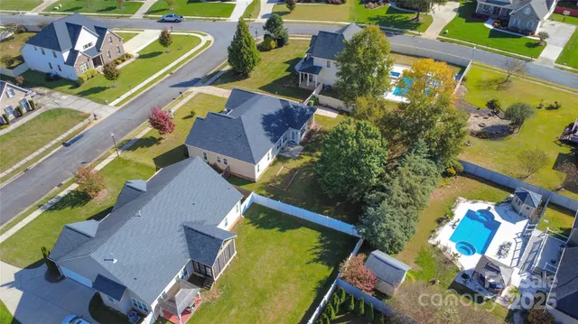 an aerial view of a swimming pool with outdoor seating