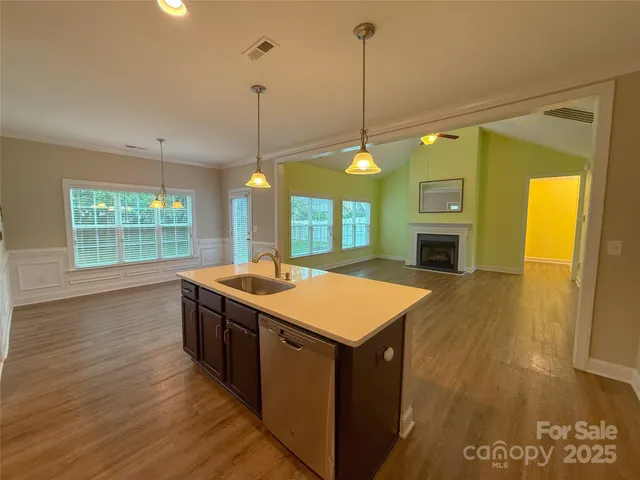 a kitchen with kitchen island a sink a stove and a wooden floor