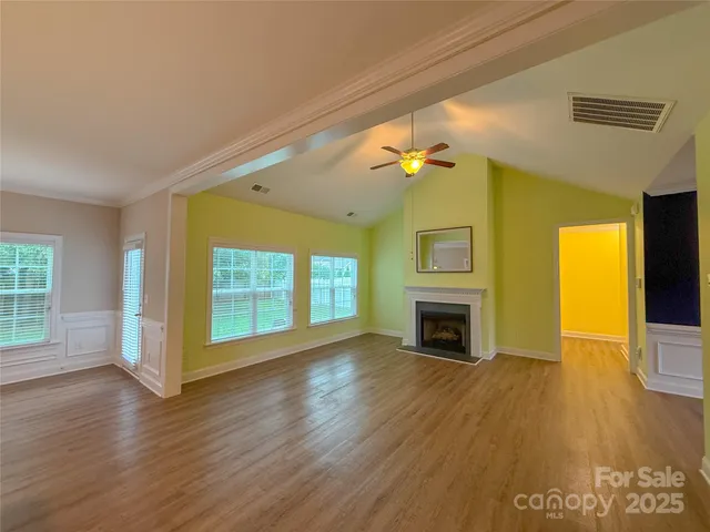 a view of a livingroom with wooden floor fireplace and window