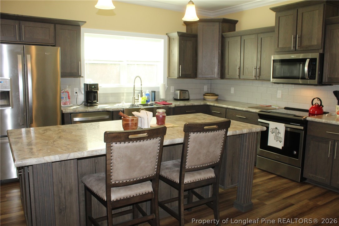 951 Lucian Hilliard Road Goldston, NC 27252 - Photo 11 of 25 a kitchen with a sink cabinets and stainless steel appliances