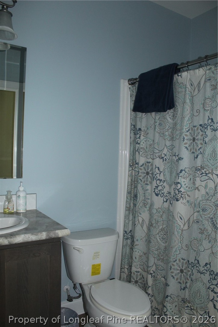 951 Lucian Hilliard Road Goldston, NC 27252 - Photo 18 of 25 a bathroom with a granite countertop toilet and a sink