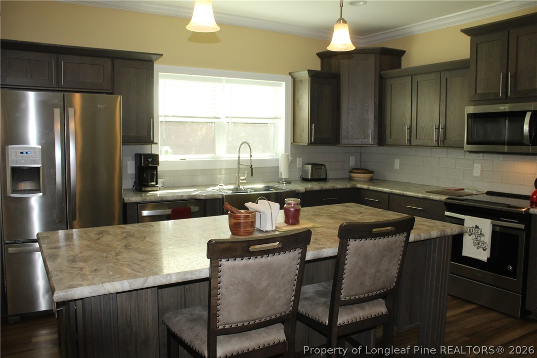 951 Lucian Hilliard Road Goldston, NC 27252 - Photo 7 of 25 a kitchen with granite countertop a refrigerator stove top oven a sink and dishwasher