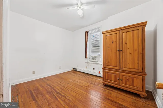 an empty room with wooden floor and cabinet