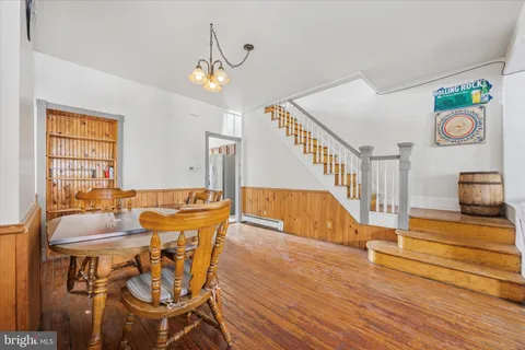 a view of a dining room with furniture a chandelier and wooden floor