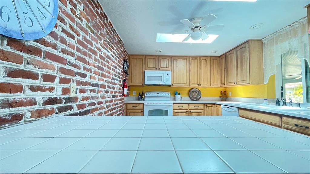 2233 Alice Road Sarasota, FL 34231 - Photo 13 of 30 a view of kitchen with stainless steel appliances granite countertop a sink a stove white cabinets with a dining table and chairs