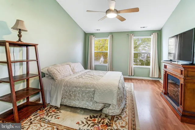 a bedroom with a bed a flat screen tv and a window