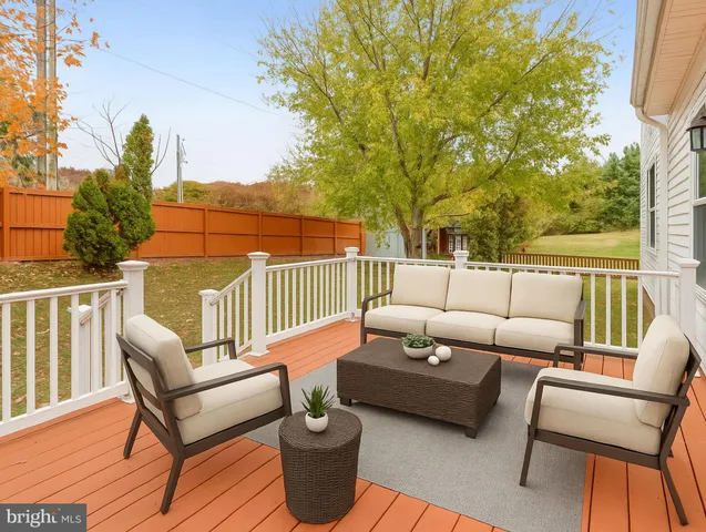 a roof deck with couches and wooden fence