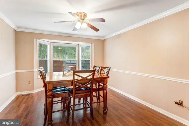 a dining room with furniture a chandelier and wooden floor