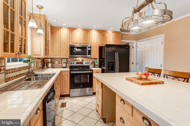 a kitchen with stainless steel appliances kitchen island granite countertop a sink stove and refrigerator