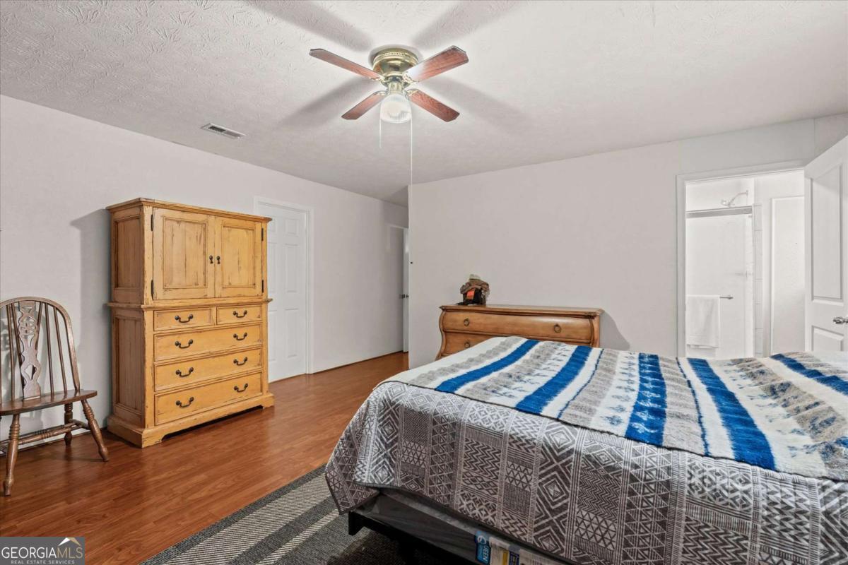 40-l Z L Z Jackson Road Bowdon, GA 30108 - Photo 13 of 32 a bedroom with a bed and wooden floor